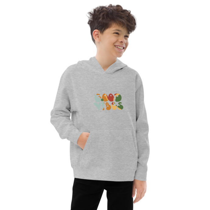 Male child wearing grey sweatshirt hoodie that displays colorful text "Good Vibes"